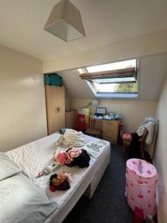Cozy attic bedroom with a double bed under a sk...