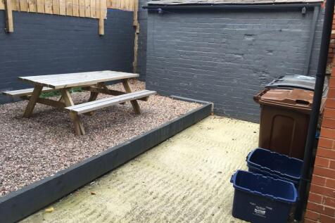 Private rear paved courtyard with raised gravel...