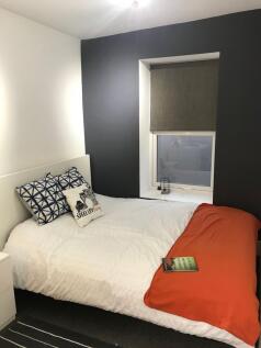 Bright, neatly styled bedroom with a comfortabl...