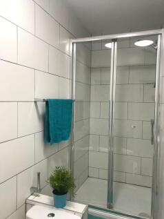 Bright, modern bathroom with a framed glass sho...