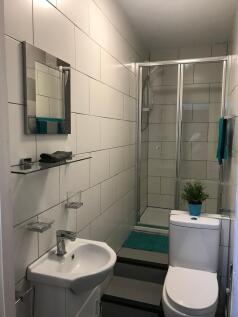 Bright, modern bathroom with white tiled walls,...