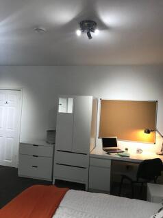 Bright, neatly furnished bedroom with a tidy st...