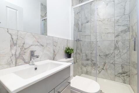 Bright, modern bathroom with a walk-in glass sh...