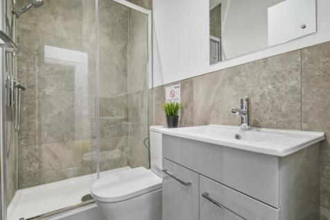 Bright, modern bathroom featuring a glass-enclo...