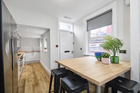 Bright, modern kitchen with wood-style flooring...