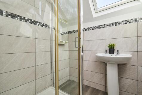 Bright, modern bathroom with a tiled walk-in sh...