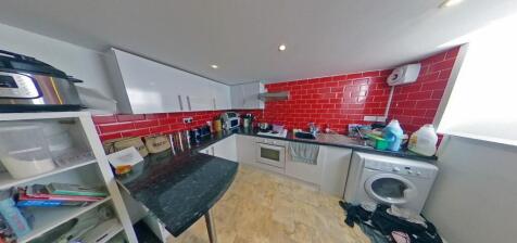 Bright modern kitchen with contemporary red spl...