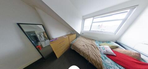 Cozy attic bedroom with a sloped ceiling and a ...