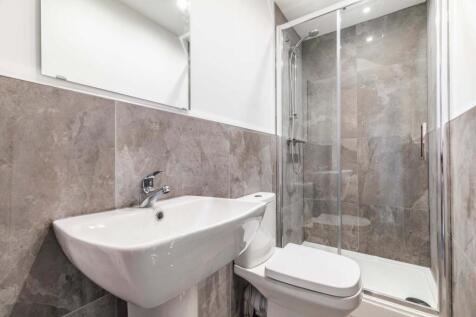 Modern bathroom with a walk-in glass shower, wh...