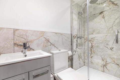 Bright, modern bathroom with marble-effect tile...