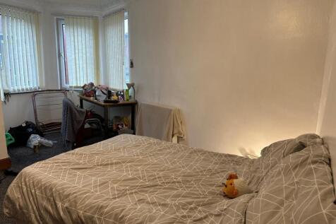 A cozy bedroom featuring a comfortably made dou...