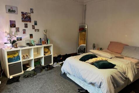 A cozy bedroom featuring a double bed with pill...