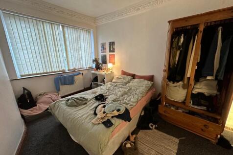 A cozy bedroom with a large window providing na...