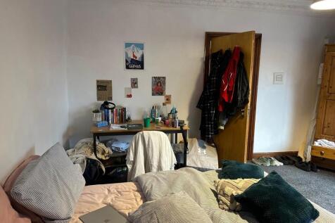 A cozy bedroom featuring a double bed, some per...