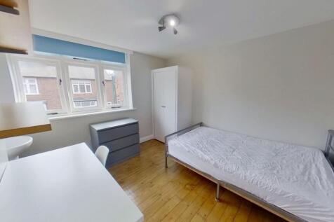 Bright, neatly furnished single bedroom with a ...