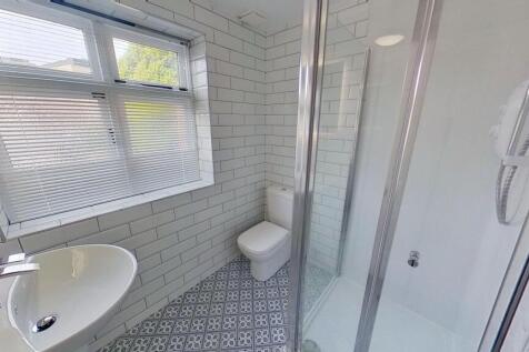 Bright, modern bathroom with patterned floor ti...