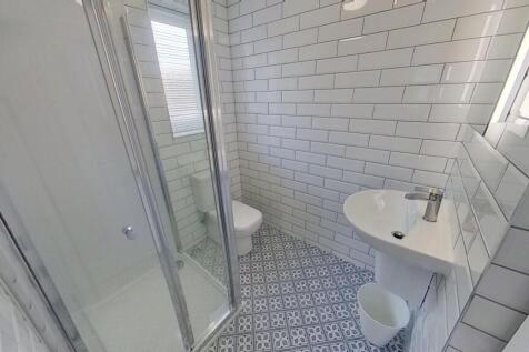 Bright, modern bathroom with patterned tiled fl...