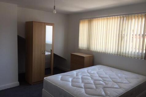 Bright, simply furnished bedroom with a double ...