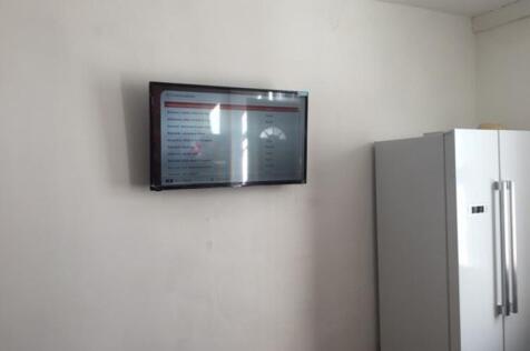 Simple kitchen area with a wall-mounted flat-sc...