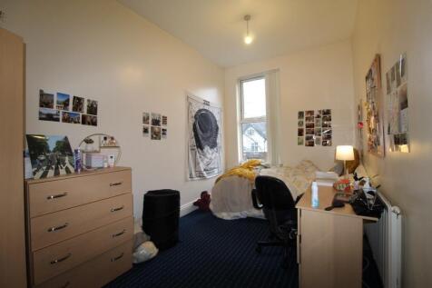 A cozy furnished bedroom with a single bed, des...