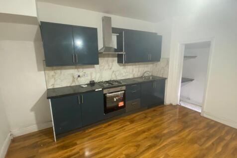 Modern kitchen with sleek dark cabinetry, built...