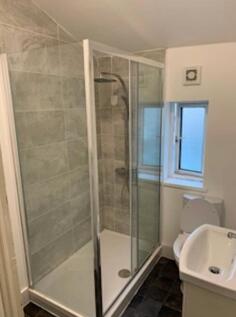 A modern bathroom featuring a stylish glass sho...