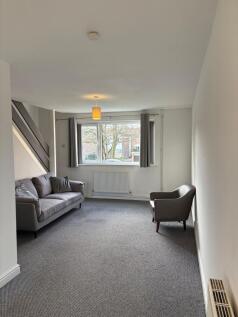 Bright, neutral living room with a large front ...