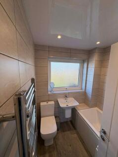 Modern tiled bathroom with a bathtub, pedestal ...