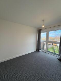 Bright, uncluttered bedroom with large window a...