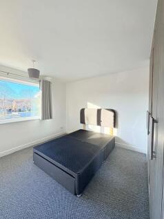 Bright, modern double bedroom with a large wind...