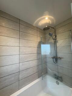 Modern tiled bathroom with a shower-over-bath, ...