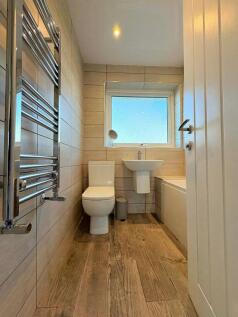 Bright, modern bathroom with wood-effect floori...