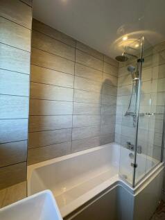 Modern bathroom suite with a fitted bath and cl...