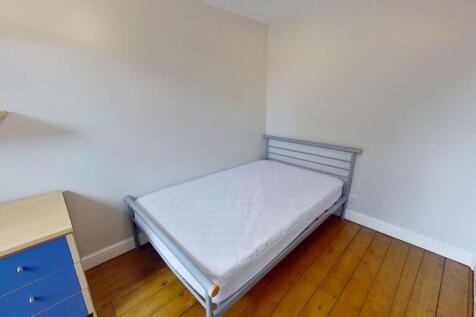 Bright, simply furnished bedroom with a single ...