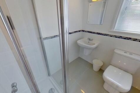 Bright, modern bathroom with a glass shower enc...