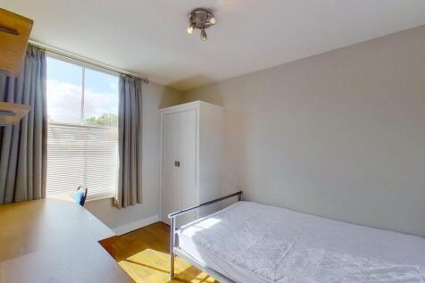 Bright, tidy bedroom with large sash window and...