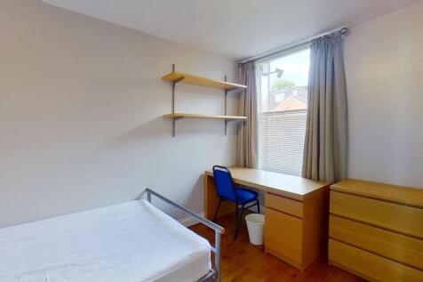 Bright, simply furnished bedroom with a single ...