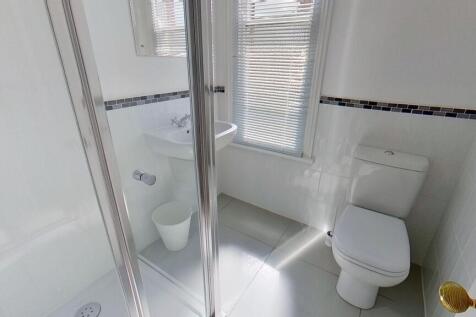Bright, modern bathroom with a corner shower en...