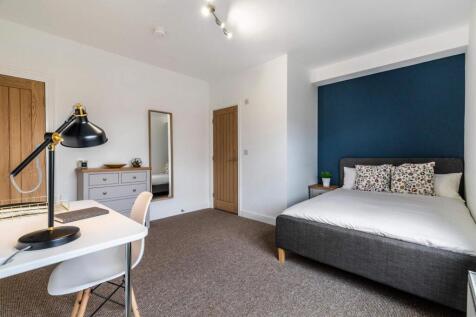 Bright, modern master bedroom with a comfortabl...