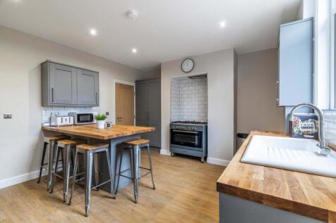 Modern kitchen with wooden worktops, central is...