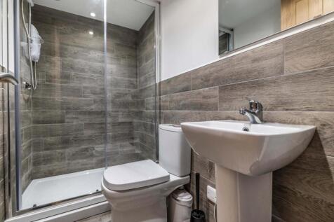 Modern ensuite bathroom featuring a walk-in gla...