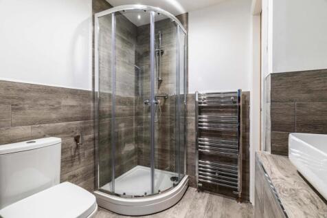 Modern bathroom with a curved glass shower encl...