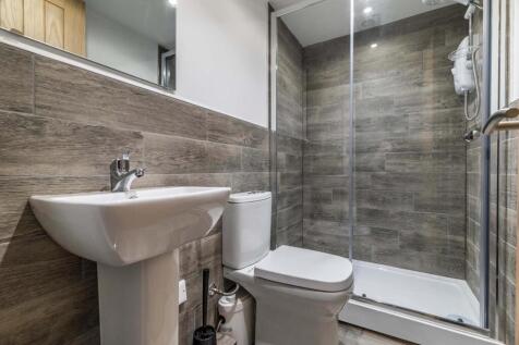 Modern tiled bathroom with a walk-in shower cub...
