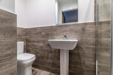 Modern bathroom with wood-effect wall tiles, wh...