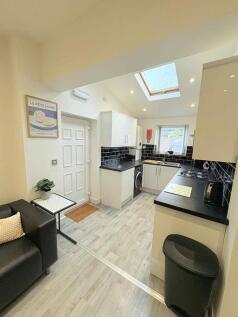 Bright modern kitchen with white cabinets, blac...