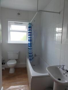 Bright and clean bathroom with a large window, ...