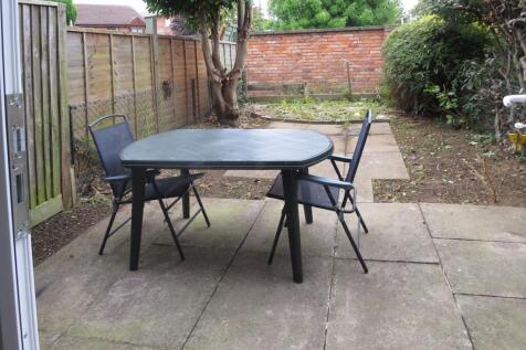 A spacious garden area with outdoor seating, pe...