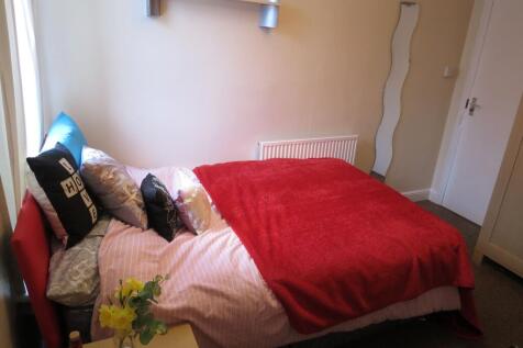 Cosy double bedroom with a red throw and decora...