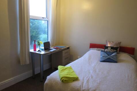 Bright single bedroom with a neatly made bed, d...