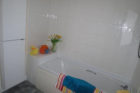 Bright, tiled bathroom featuring a built-in bat...